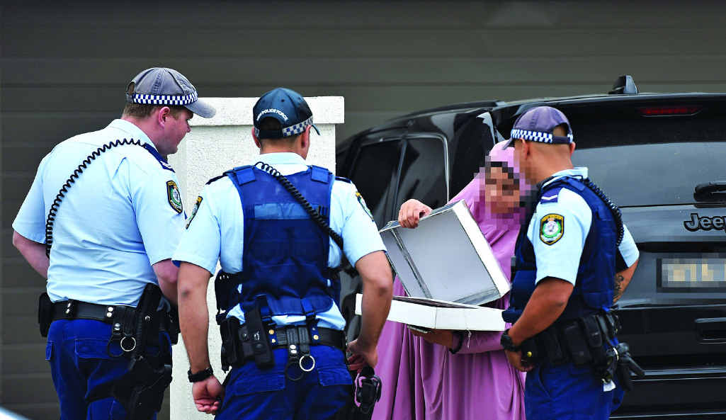 STRESSFUL TIME: NSW Police officers question the occupant of a Merrylands house raided yesterday morning. STRESSFUL TIME: NSW Police officers question the occupant of a Merrylands house raided yesterday morning.